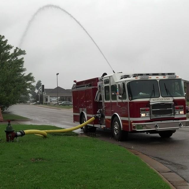 Water spraying in arch from the top of the fire engine during pumper training