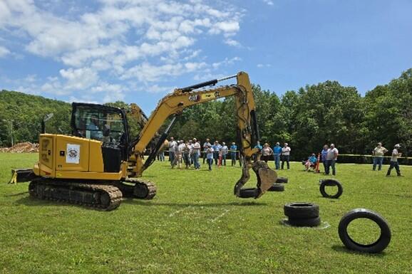 Mini Ex Operator stacking tires at 'Roadeo'